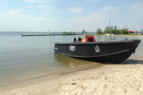 Tideman Marine HDPE hull work boat with its bow pulled up onto the sand at a beach